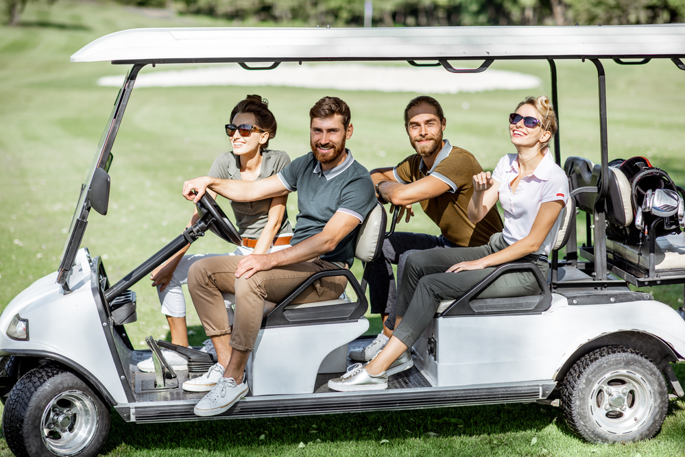 People in the golf car on the playing course